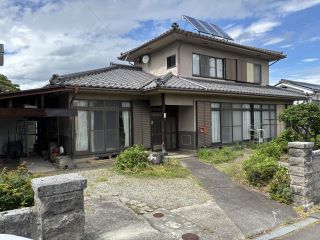 日本瓦屋根の白い建物で2階屋根には太陽光発電がある木造2階建ての建物の外観写真