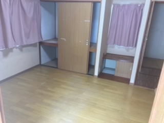 左側に閉じたカーテン、中央奥に押入れ、物入れがある洋室内観写真