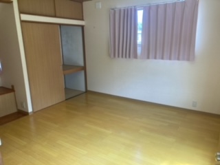 左側に押入れ、中央奥にカーテンが閉じている洋室内観写真