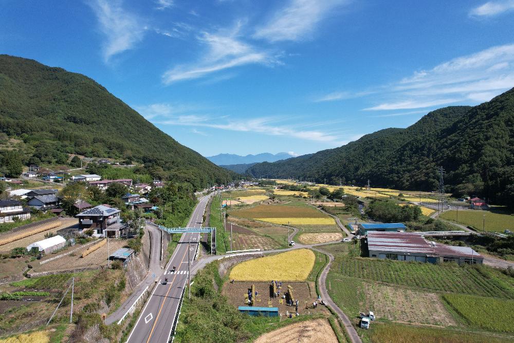 青い空と深い緑の山々、田園風景を捉えた写真