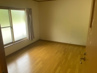 左側にサッシ、その右側にカーテンがある洋室内観写真