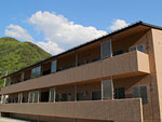 茶色の建物で2階建ての四泊町営住宅の外観写真